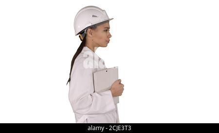 Attractive Hispanic woman in white lab coat and white safety har Stock Photo