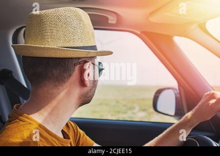 Young handsome man in straw hat driving car Stock Photo