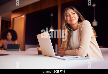 Businesswoman With Laptop At Socially Distanced Meeting In Office During Health Pandemic Stock Photo