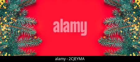 Fir branches with blurred lights garland on a red background. Stock Photo