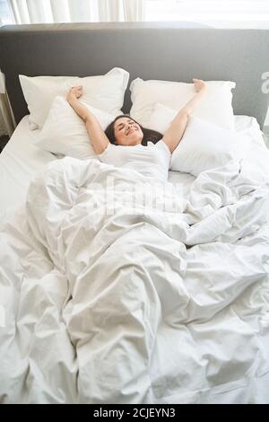 Female stretching herself after waking up in the morning Stock Photo