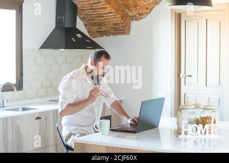 hipster guy with a beard working on his laptop at home Stock Photo