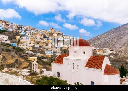 Typical Greek Orthodox Church with Colorful Town on a Mountain Peak in the Background, Olympos, Karpathos, Greece Stock Photo