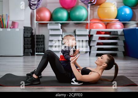 Mother laying on a mat and playing with her child Stock Photo