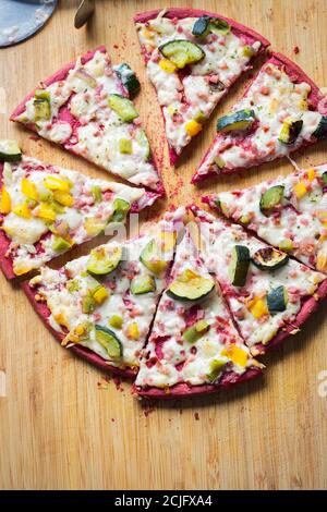 Beetroot dough vegetarian pizza with yellow peppers and courgettes Stock Photo