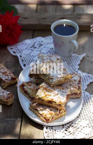 Streusel pie stuffed with rose jam, served with coffee. Rustic style. Stock Photo