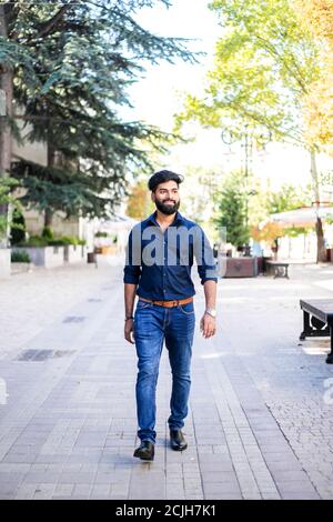 Young Indian man walking in the street. Stock Photo