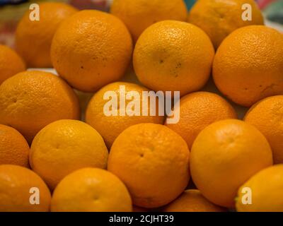 A pile of oranges sitting on top of a wooden table Stock Photo