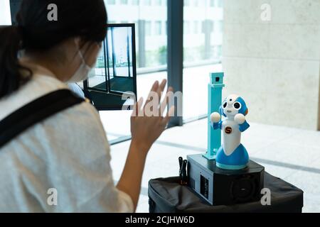 (200915) -- TOKYO, Sept. 15, 2020 (Xinhua) -- A visitor interacts with a robot during a test at a commercial building in Tokyo, Japan, on Sept. 14, 2020. The event, as a part of Tokyo metropolitan government's 'Tokyo Robot Collection' project, tests the operation of robots on guiding, temperature measuring, telepresence, and other functions which help people reduce the risk of COVID-19 infection. (Tokyo metropolitan government/Handout via Xinhua) Stock Photo