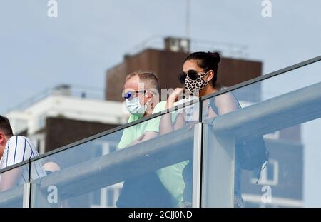 Brighton UK 15th September 2020 -  Visitors wearing face coverings on Brighton seafront make the most of another hot day by the seaside as temperatures are again expected to reach 30 degrees in some parts of the South East    : Credit Simon Dack / Alamy Live News Stock Photo