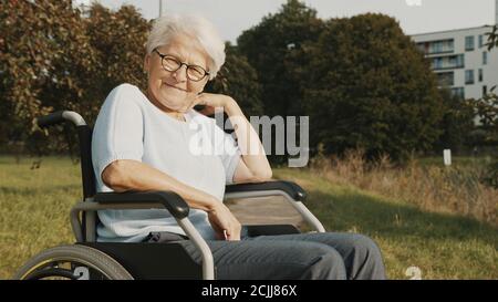 Happy granny in the wheelchair enjoying autumn day near the river. High quality photo Stock Photo