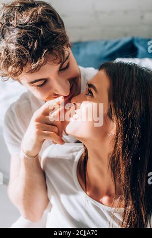 Young man looking at girlfriend and pointing with finger Stock Photo