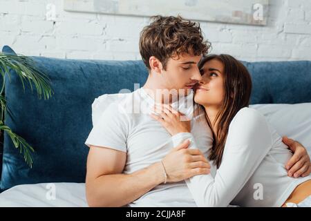 Young couple lying on bed and looking at each other Stock Photo