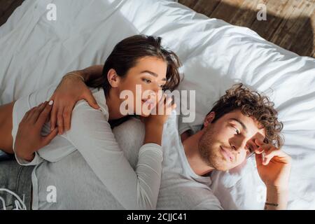 High angle view of couple in pajamas lying on bed at morning Stock Photo