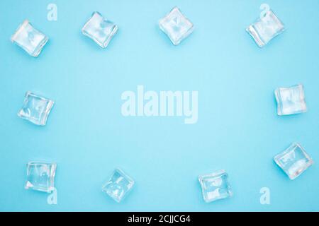 Ice cubes in the form of a frame on a blue background. Free space for text. Copyscape. Stock Photo