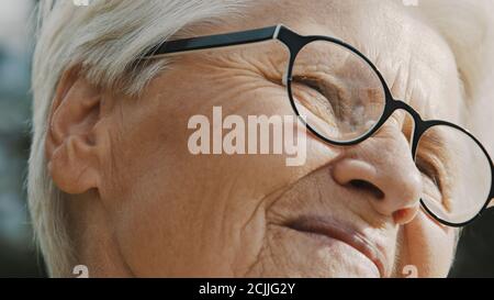 Old woman face epression while enjoying breeze on the sunny autumn day. High quality photo Stock Photo