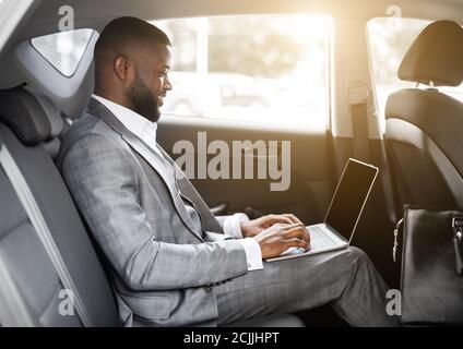 Black guy businessman working on laptop with blank screen Stock Photo