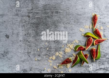 Flat lay composition with whole and cut purple figs and space for text on gray background Stock Photo