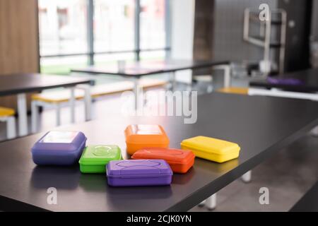 colorful plastic lunch boxes on table in school canteen Stock Photo