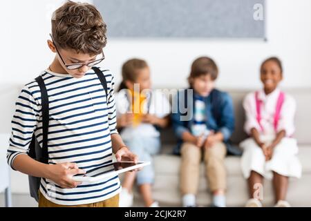 Selective focus of schoolboy using digital tablet in classroom Stock Photo