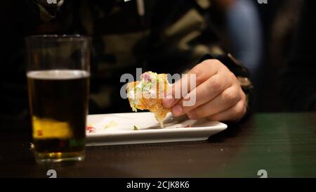 Man eating a sandwich and drinking beer Stock Photo
