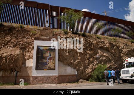 A food vendor operates along the border wall with Nogales, Arizona, USA, in Nogales, Sonora, Mexico. Stock Photo