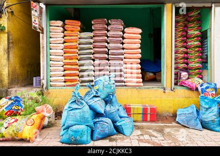 Close-up of a store in the Philippines selling exclusively different brands and qualities of rice. Sacks of rice are piled up in an open storage place Stock Photo