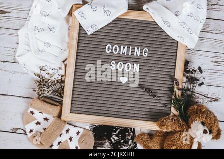 Coming soon sign. Baby announcement sign on a rustic white background. Coming soon concept. Stock Photo