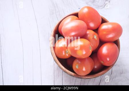 top view of fresh tomato in bowl on wooden table  Stock Photo