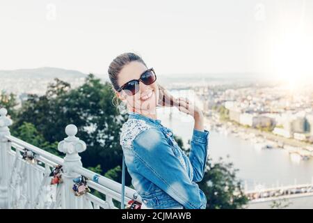 Happy young 30s Hungarian urban woman with toothy smile and holding hair, Budapest, Hungary Stock Photo