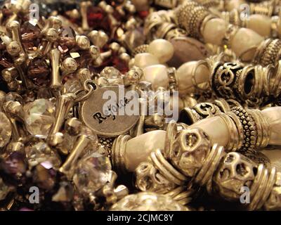 Close-up of pretty faux pearls and rondelle crystal beads bracelets or rosaries with a Tibetan zinc alloy in silver color pendant that reads Rejoice Stock Photo