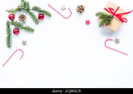 Christmas frame made of fir branches, red candy, cones, decorations. Christmas or New Year background. Flat lay, top view, copy space. Stock Photo