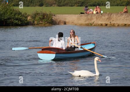 People enjoying the autumn sunshine on a rowing boat on the River Thames near Windsor and Eton, Berkshire. Stock Photo