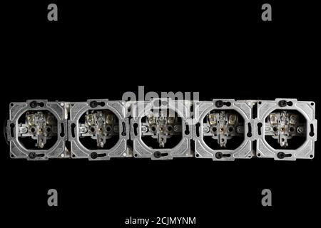 Five outlets in line, disassembled and mounted in black glass wall. Stock Photo