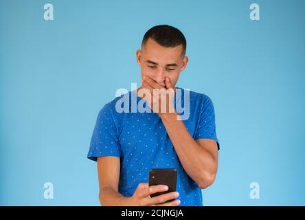 Surprised young man talking to mobile Stock Photo