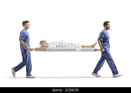 Full length profile shot of healthcare workers carrying a female patient on a stretcher isolated on white background Stock Photo