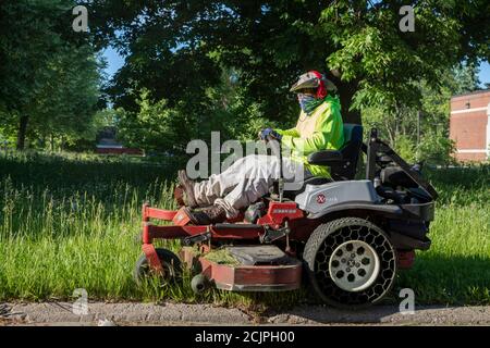Detroit, Michigan - Workers from the Detroit Grounds Crew cut the grass on the grounds of the Burbank School, one of dozens of closed public schools i Stock Photo