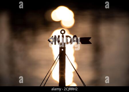 Nida, Lithuania, logo with reflections of the sun on the water on background Stock Photo