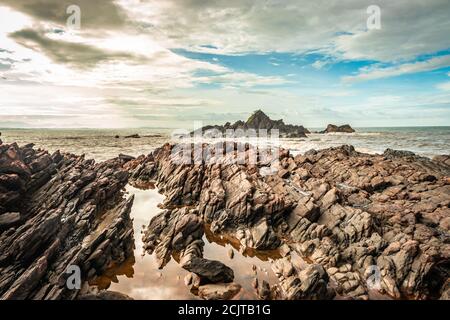natural rock formation at sea shore due to crashing waves at morning from flat angle image is taken at om beach gokarna karnataka india. it is one the Stock Photo