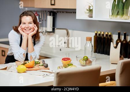 Happy young housewife posing to the camera in the modern kitchen. break time. rest and relaxation concepts Stock Photo
