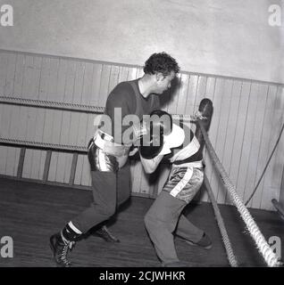 1960s, historical, two male boxers in a rig boxing at a youth club, Bowhill, Scotland. The Cardenen Amateur Boxing Club began in the pit village in 1919 just after WW1 to enable young people learn the skills of the noble art and was known at this time as the Bowhill Miners Welfare Boxing Club. Stock Photo