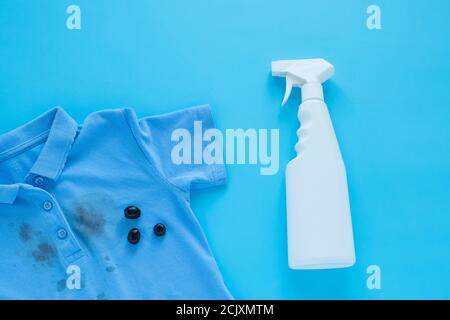 stains of dirty black olives on clothes and stain remover. Stain cleaners. Isolated on a blue background Stock Photo