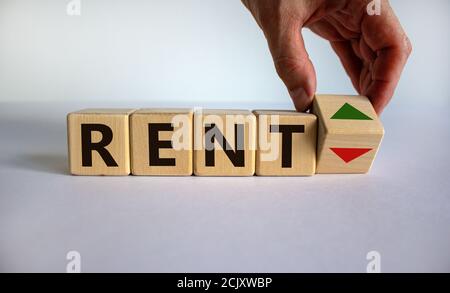 Symbol for increasing rent. Hand is turning a cube and changes the direction of an arrow symbolizing that rents are going up or vice versa. Beautiful Stock Photo