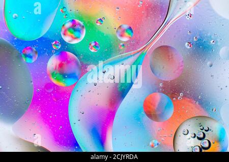 Iridescent abstract macro background of oil drops on the water surface with bubbles Stock Photo