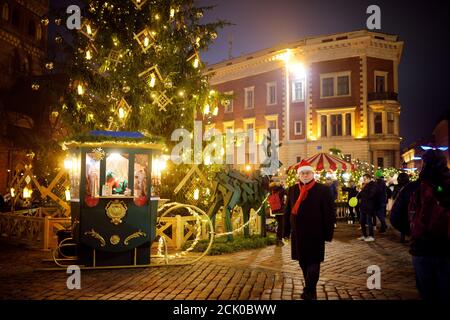 RIGA, LATVIA - DECEMBER 20, 2019: People enjoying the most authentic Christmas market in Riga offering dozens of crafts and food stalls, as well as gi Stock Photo