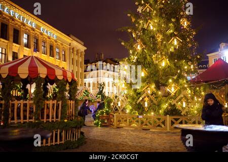 RIGA, LATVIA - DECEMBER 20, 2019: People enjoying the most authentic Christmas market in Riga offering dozens of crafts and food stalls, as well as gi Stock Photo