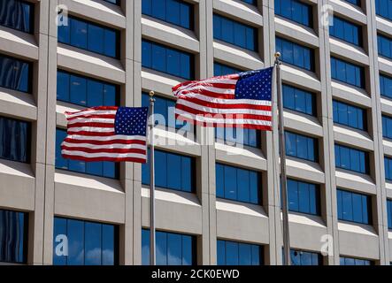 Two American Flags fly in the breeze in front of a building in Lower Manhattan, NYC. These flags are part of the New York Vietnam Veterans Memorial Pl Stock Photo