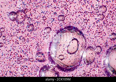 Macro of transparent glowing slime with glittering particles and bubbles inside Stock Photo