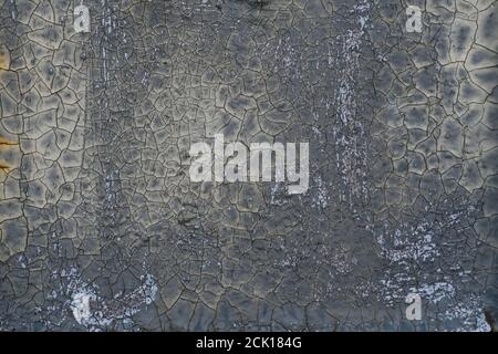 Cracked flaking gray paint on monastery wall, background texture. Surface with old weathered peeling grey paint . Stock Photo