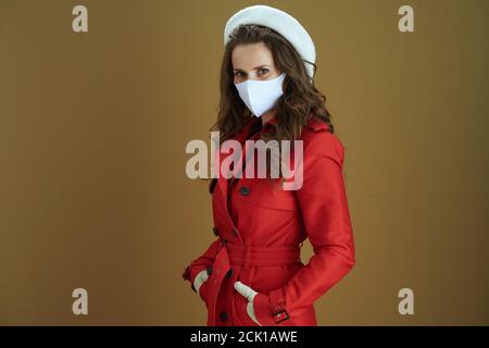 Hello autumn. trendy middle aged woman in red coat on brown background. Stock Photo